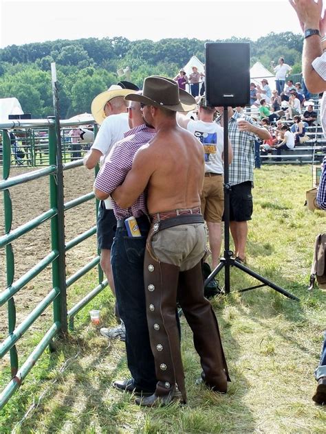 Men In Cowboy Hats Are Standing Near A Fence