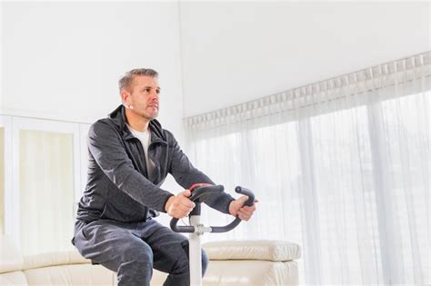 Premium Photo Caucasian Man Sitting On A Spin Bike At Home