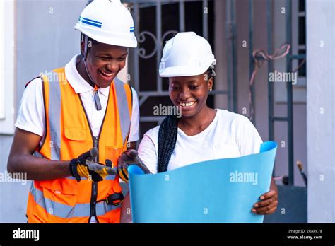 African Male And Female Industrial Engineers Looking At Blueprints