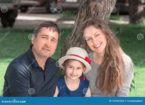 Familia Con Dos Ni Os Que Se Sientan En Un Banco De La Ciudad Foto De