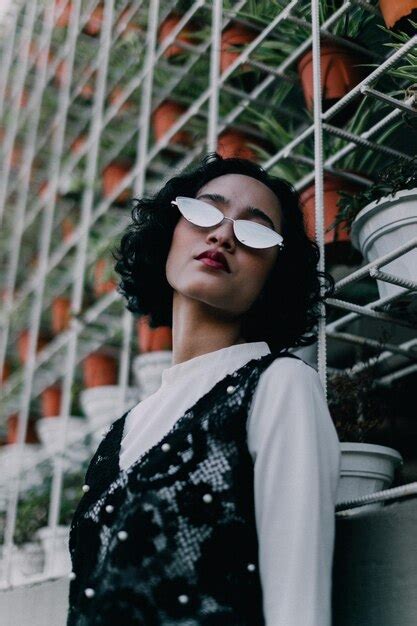 Premium Photo Portrait Of Woman Wearing Sunglasses Standing Against