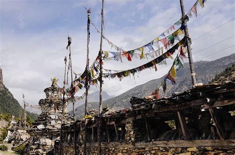 Tibetan Prayer Flags Adorn Ancient Stone Ruins With Majestic Mountains