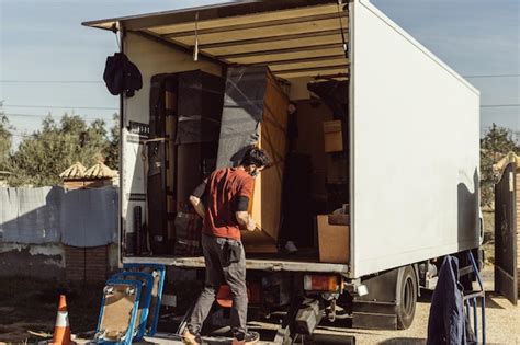 Premium Photo | Two men loading a piece of furniture onto a moving truck