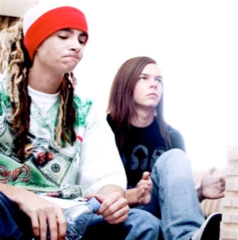 Two People Sitting On A Couch With One Person Wearing A Red Beanie