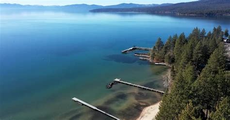 Drone flyover of the North shore of Lake Tahoe, shoreline lined with ...