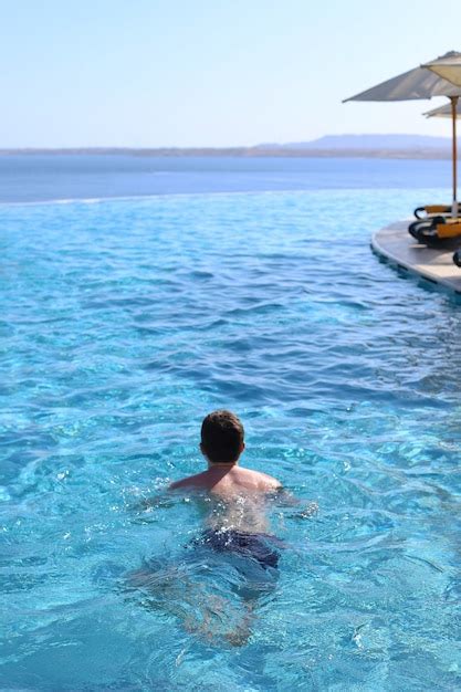 Chico Joven Nada En La Piscina Azul Abierta Foto Premium