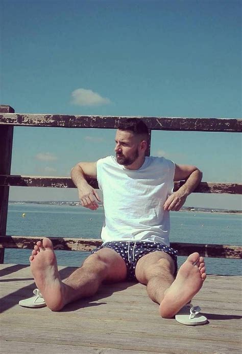 A Man Sitting On A Dock With His Legs Crossed