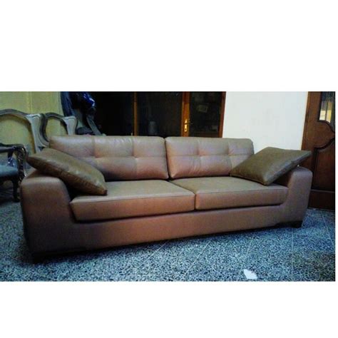 A Brown Leather Couch Sitting On Top Of A Carpeted Floor