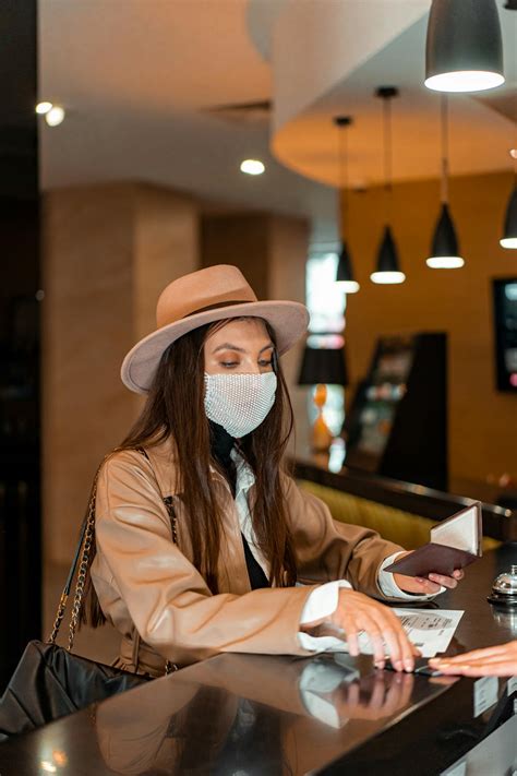 Woman In Brown Coat And White Hat Sitting At The Table · Free Stock Photo