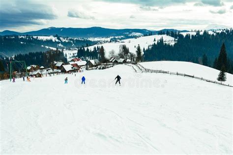 Skier in Professional Equipment Rushes from the Mountain in the Village ...