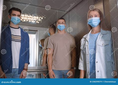 Group Of People With Face Masks In Elevator Protective Measure Stock