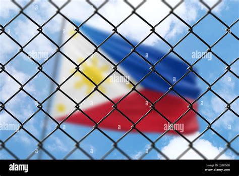 A Steel Mesh Against The Background Of A Blue Sky And A Flagpole With