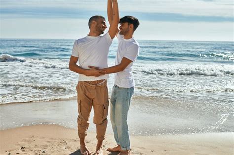 Joven Pareja Gay Sonriendo Feliz Bailando En La Playa Foto De Archivo