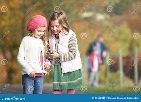 Two Young Girl Listening To Mp3 Player Outdoors Stock Photo Image Of