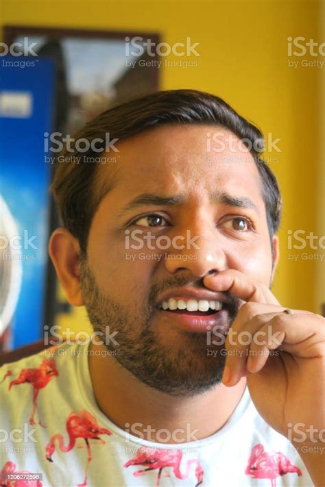 Image Of Young Handsome Indian Man Being Silly With Finger On Lips