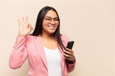 Mujer latina joven que se siente feliz relajada y satisfecha mostrando aprobación con gesto
