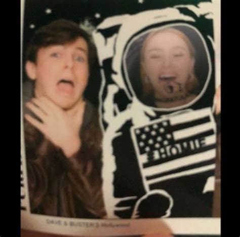 An Old Photo Of Two People In Space With One Holding Up His Mouth And