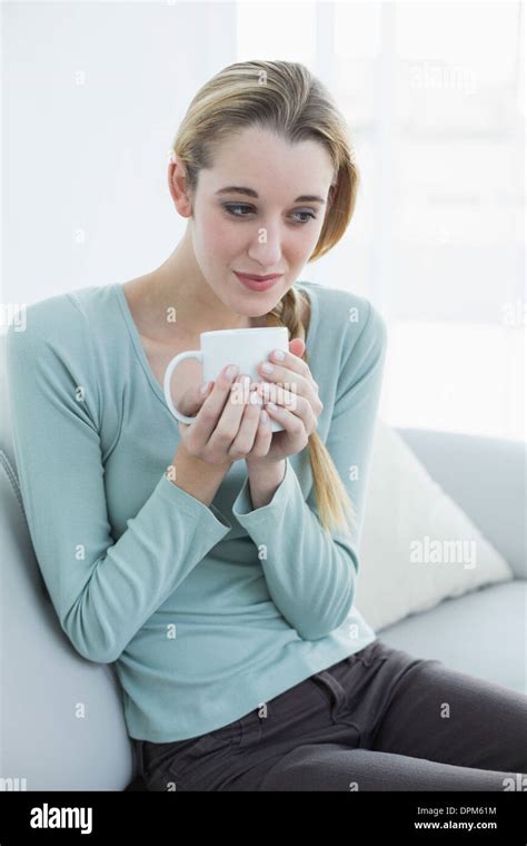 Gorgeous Relaxing Woman Sitting On Couch Holding A Cup Stock Photo Alamy