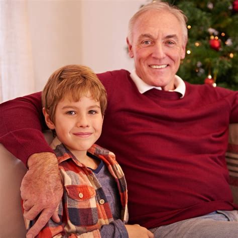 Älterer mann enkel und weihnachtsporträt auf dem sofa mit