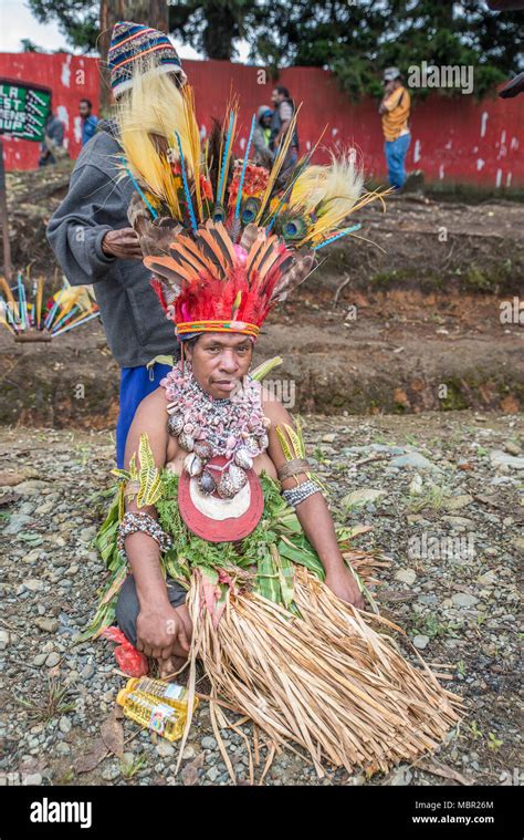 A woman with traditional costume having her feathers headdress adjusted ...