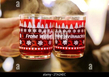 Zwei Gläser Glühwein in der Hand auf dem Lucia Weihnachtsmarkt in der