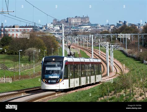 Edinburgh tram on route from the city centre to the airport with Edinburgh castle in the ...