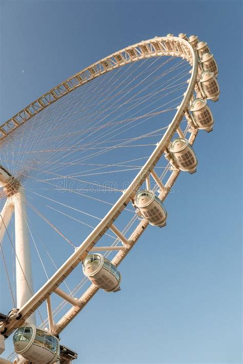 White Ferris Wheel With Glass Light Blue Cabins Against Blue Sky Dubai