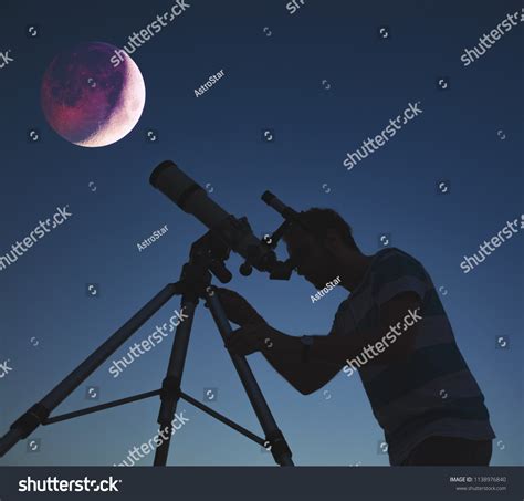 Man Looking Lunar Eclipse Through Telescope Stock Photo 1138976840