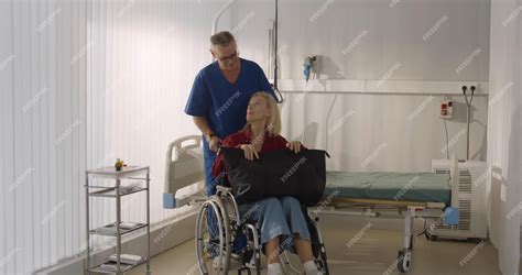 Premium Photo | Male orderly pushing senior female patient being ...