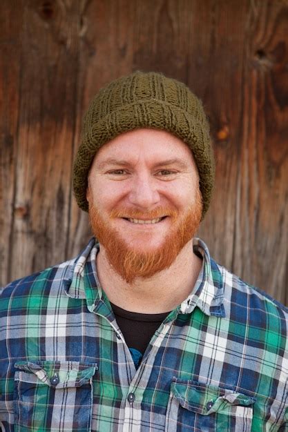 Premium Photo Portrait Of Smiling Man Standing Against Wall