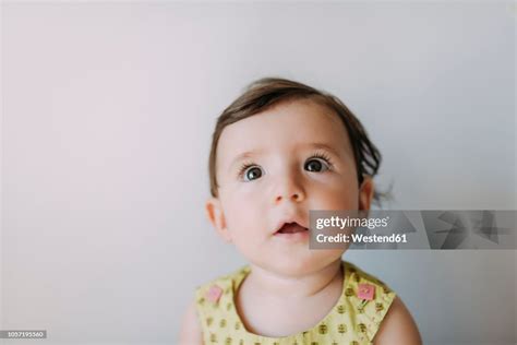 Surprised Baby Girl Looking Up On White Background High Res Stock Photo