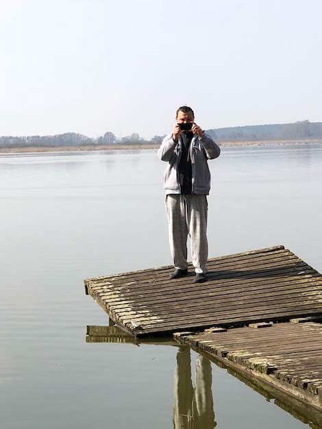 Premium Photo Man Photographing While Standing On Pier Over Lake