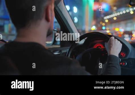 Man Driving Car Through The Streets Of Night City Glare In The Window