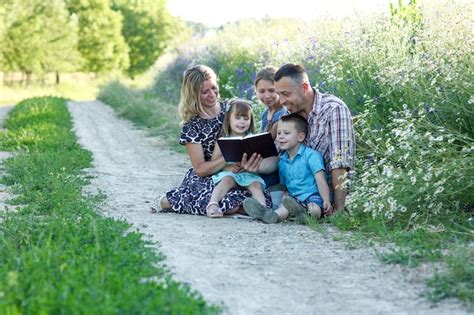 Joven Familia Feliz Con Niños Leyendo La Biblia Foto Premium