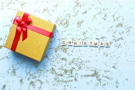Flat Lay Christmas T On A Blue Background Sparkles Word Christmas