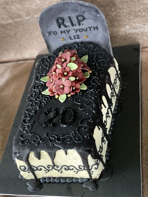 A Decorated Tombstone Cake With Flowers On Top