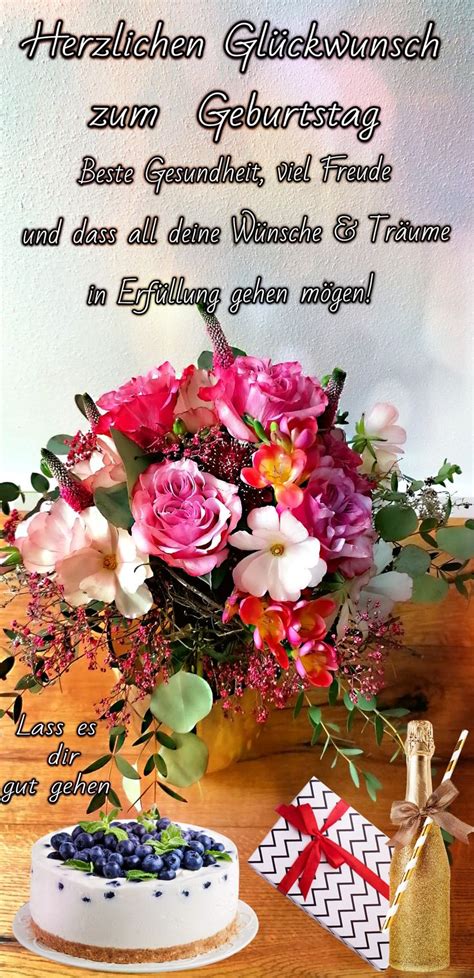 A Cake And Flowers On A Table With A Greeting Card In The Background