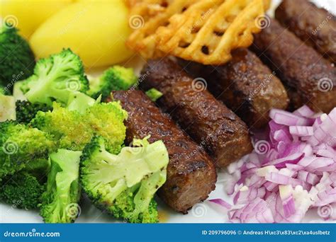 Close Up Of Grilled Cevapcici With Broccoli Red Onions And Potatoes