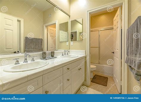 Interior of a Small Bathroom with a Double Sink Vanity Area and Wood Cabinets Stock Photo ...