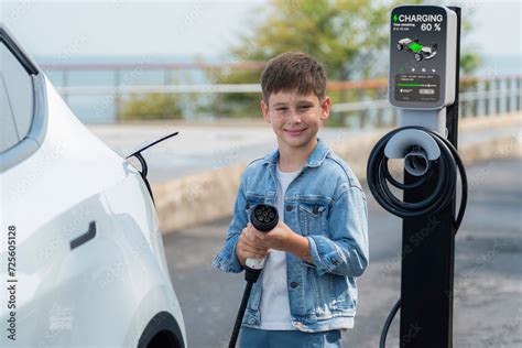 Little boy recharging eco-friendly electric car from EV charging ...