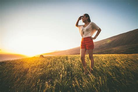 Woman Standing Green Grass Field Orange Shorts Stands Field