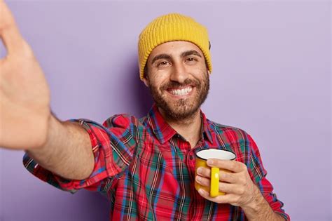 Free Photo Handsome Cheerful Smiling Man Extends Hand Holds Yellow