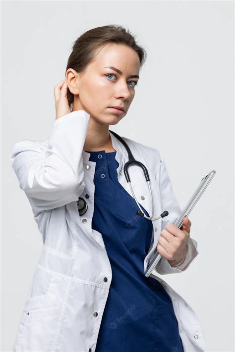 Premium Photo A Female Doctor In A White Coat With A Stethoscope Holds A Laptop In Her Hands