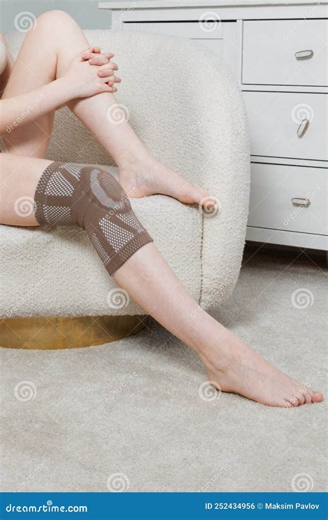 Knee Support Brace On A Woman Leg Girl In An Orthosis In The Interior