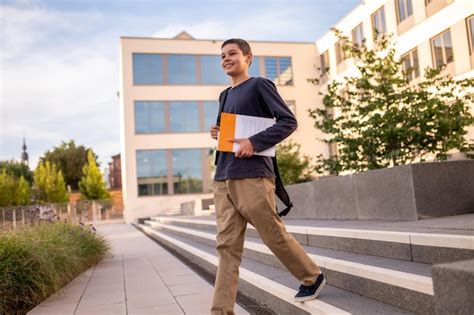 Premium Photo Joyous Determined Cute Teenage Boy With A Book Under