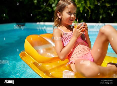 Kleines Mädchen im Schwimmbad entspannen genießen suntans trinken Sie