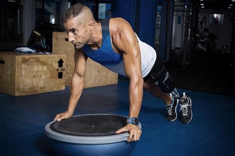 Premium Photo Determined Disabled Man Doing Push Ups On Bosu Ball At Gym