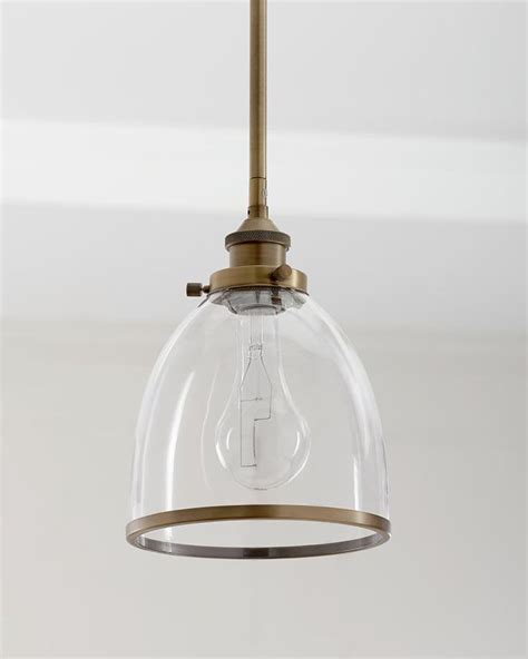 A Light Fixture With A Clear Glass Dome Hanging From It S Brass Metal Frame