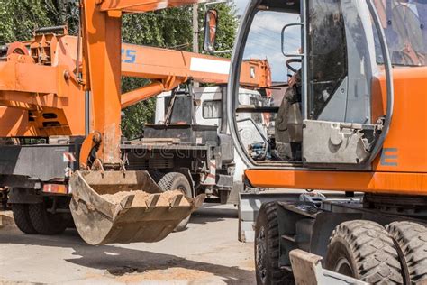 Excavation Works A Tractor Bucket Unloads Sand Ground With A Heavy