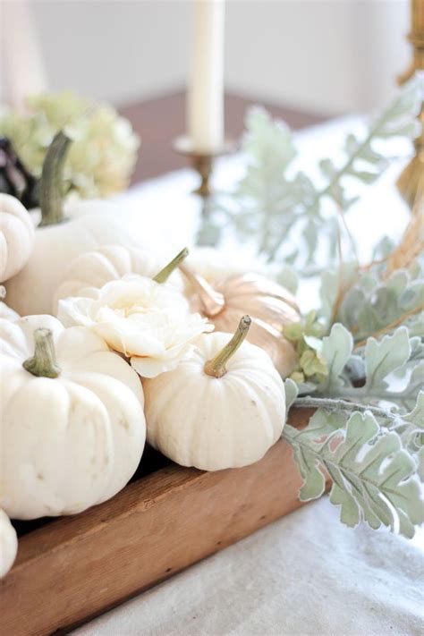 White Pumpkins And Greenery Sit On A Wooden Tray In Front Of A Candle